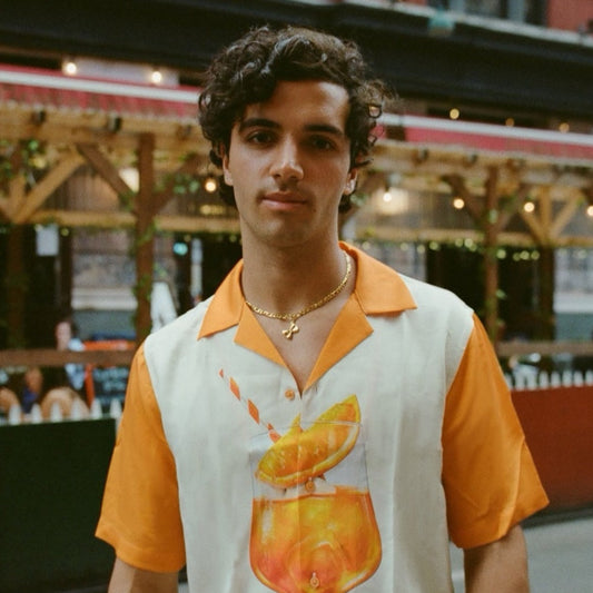 Man wearing chunky gold chain necklace with farfalle charm