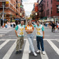 2 guys and a girl standing in the middle of the road in Little Italy. They are wearing shirts with Spritzes and farfalle pasta on them 